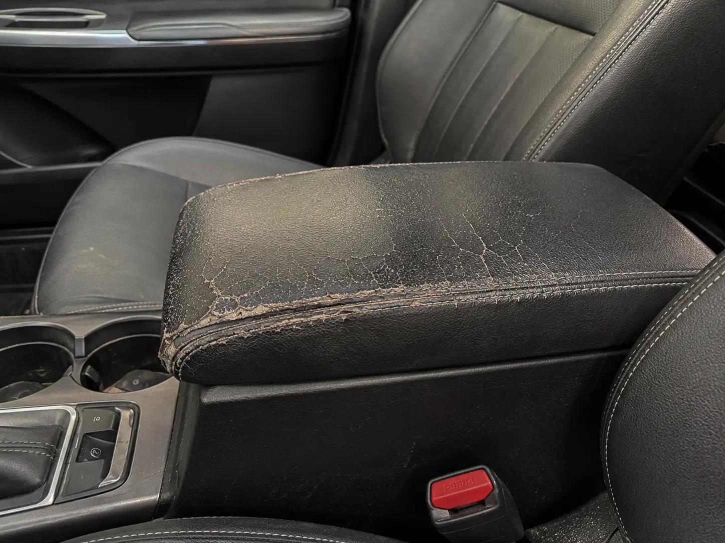 Before vehicle center armrest upholstery repair
